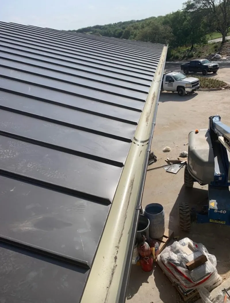 Standing seam panel and gutter detail on a metal roofing jobsite in Grafton
